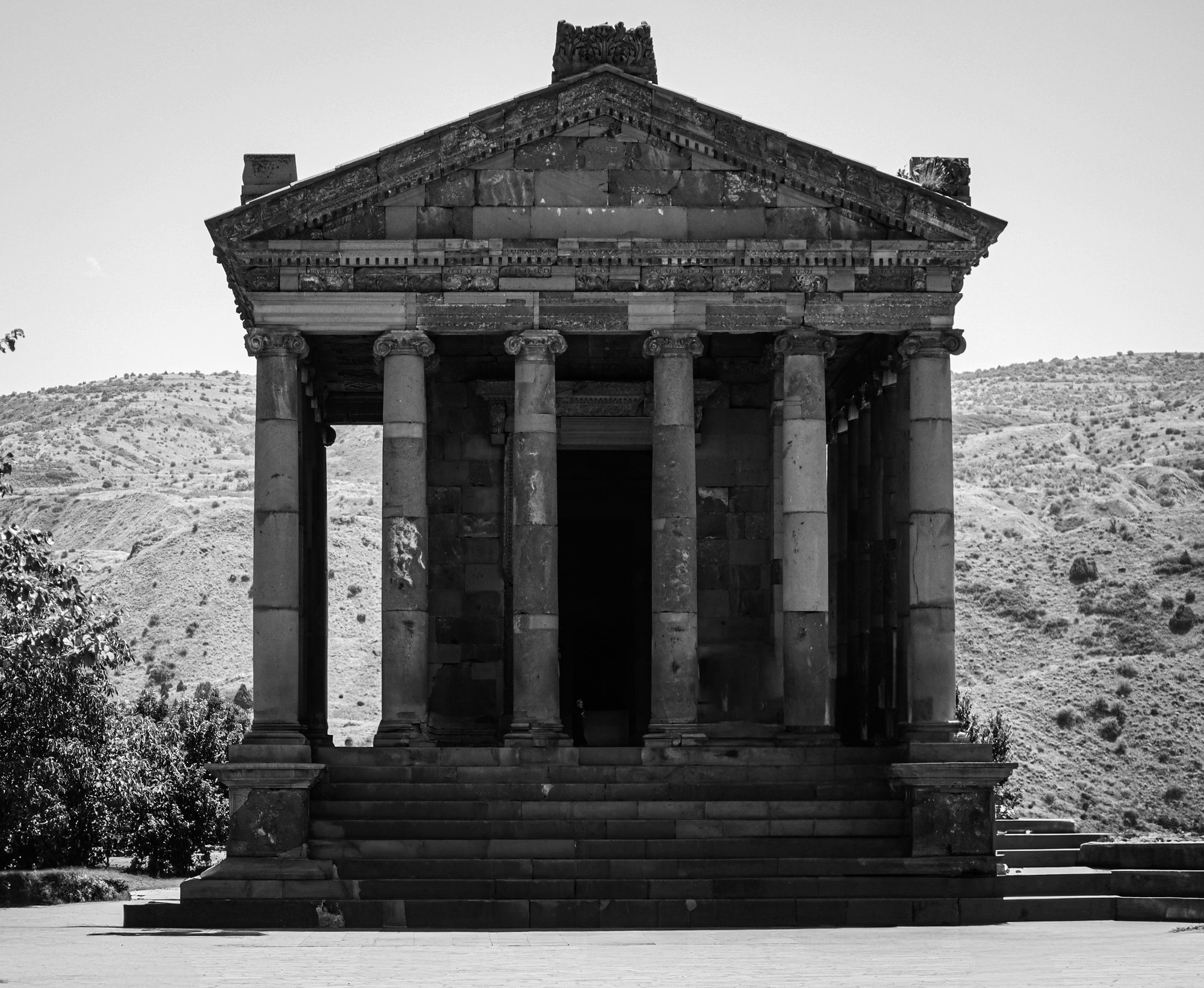 Garni Temple in black and white — the perfectly preserved Hellenistic pagan temple of Armenia, columned facade against a bright sky