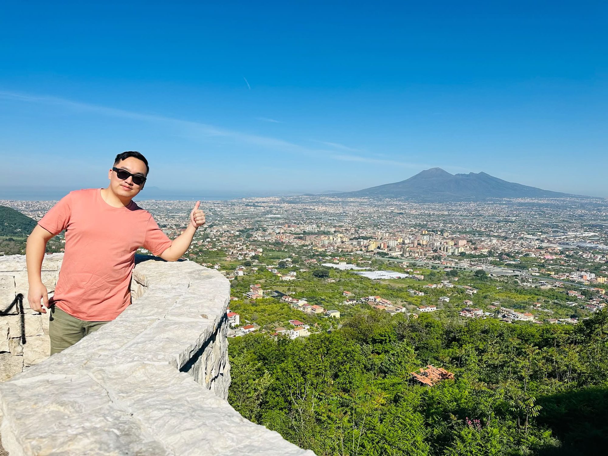 Sam at a mountainside viewpoint above the Bay of Naples, with Mount Vesuvius rising across the landscape behind him