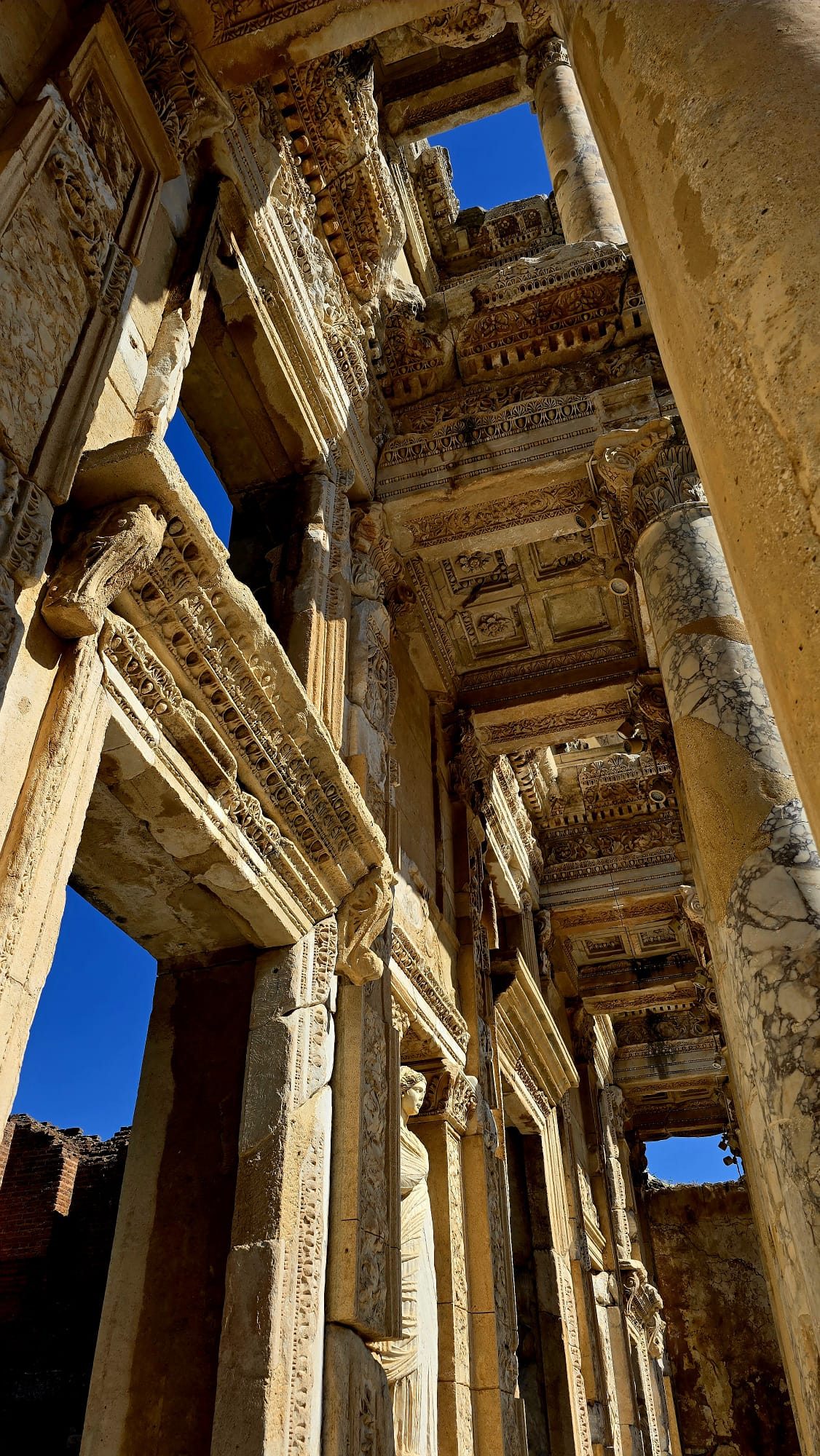 The Library of Celsus at Ephesus — its towering two-storey marble façade with columns and statue niches, seen straight on