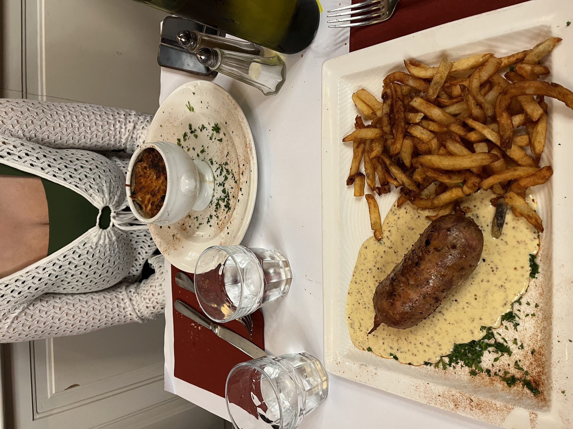 A traditional Lyonnaise bouchon meal — andouillette sausage with mustard sauce and a generous side of frites, classic French bistro plating
