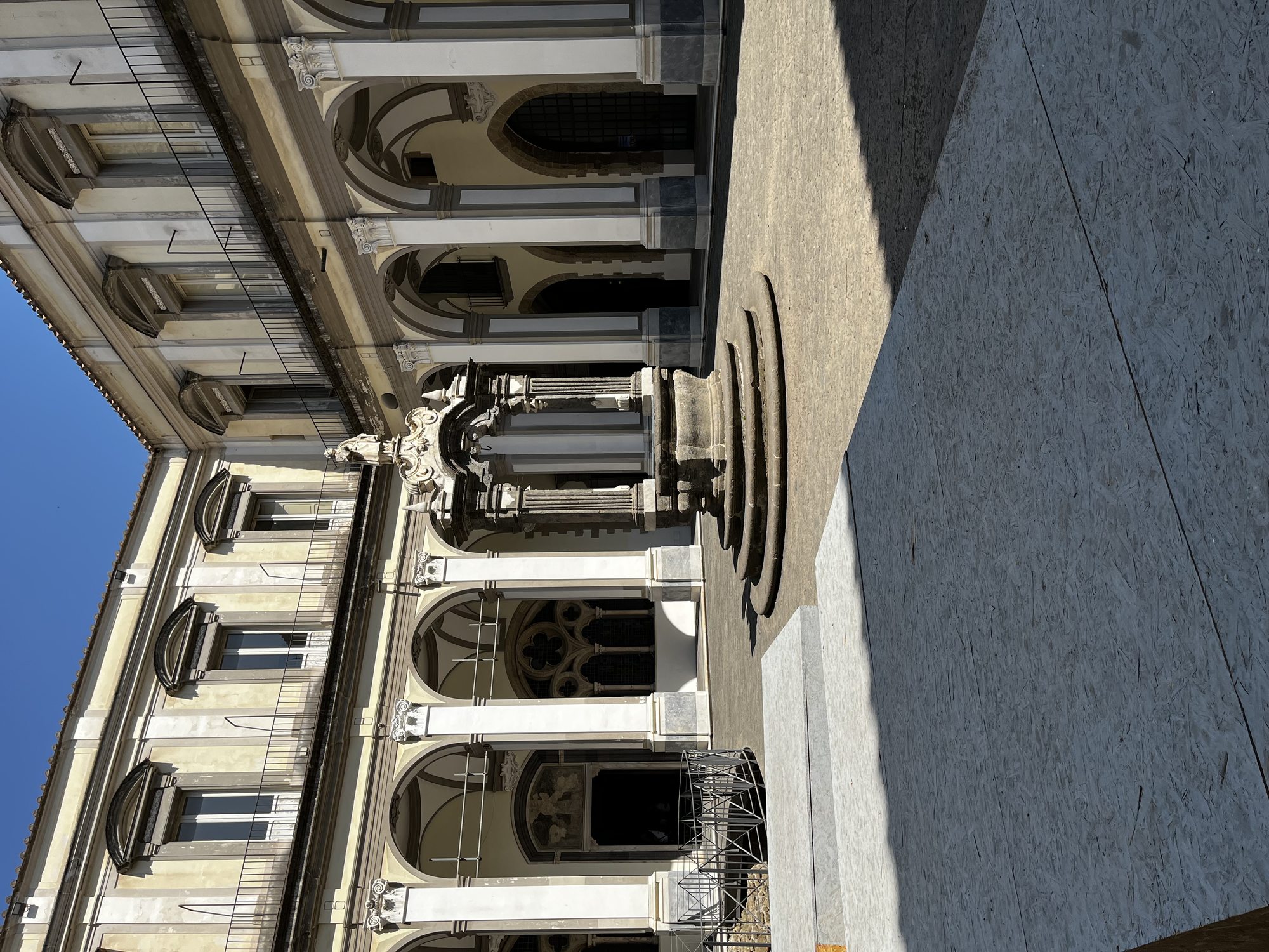 Neoclassical arched colonnade and central marble plinth inside the Galleria Principe di Napoli — long lines of slim columns and museum-quality stone work